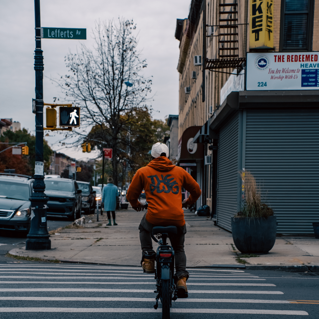 Man riding bike wearing The Plug merch
